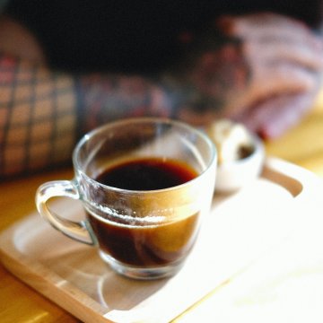 a cup of coffee in a clear glass double walled cup